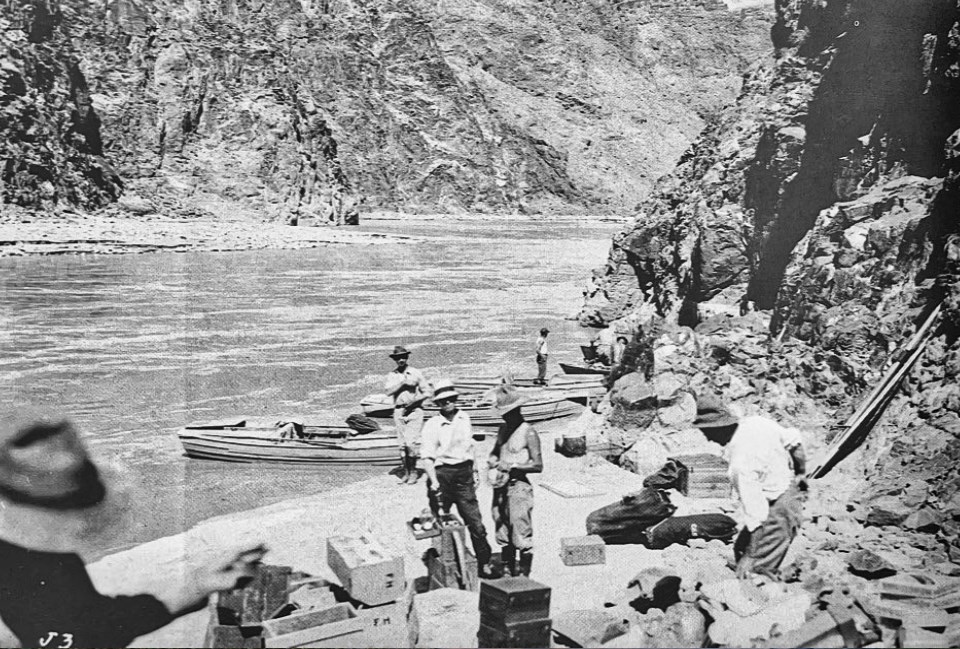 Men with boats on river with cliffs