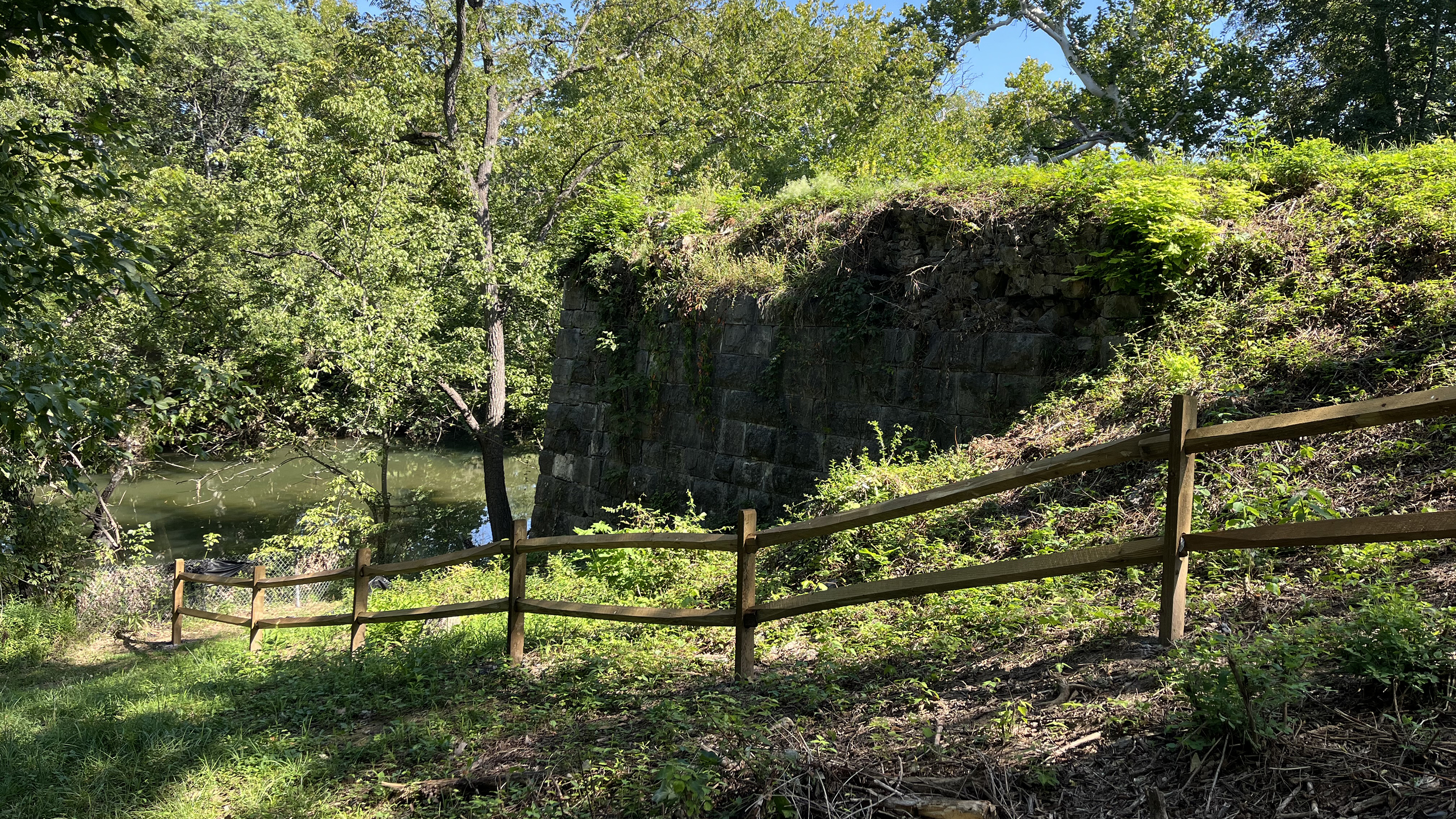 Stone bridge abutment ruins on the right bank of wide creek.
