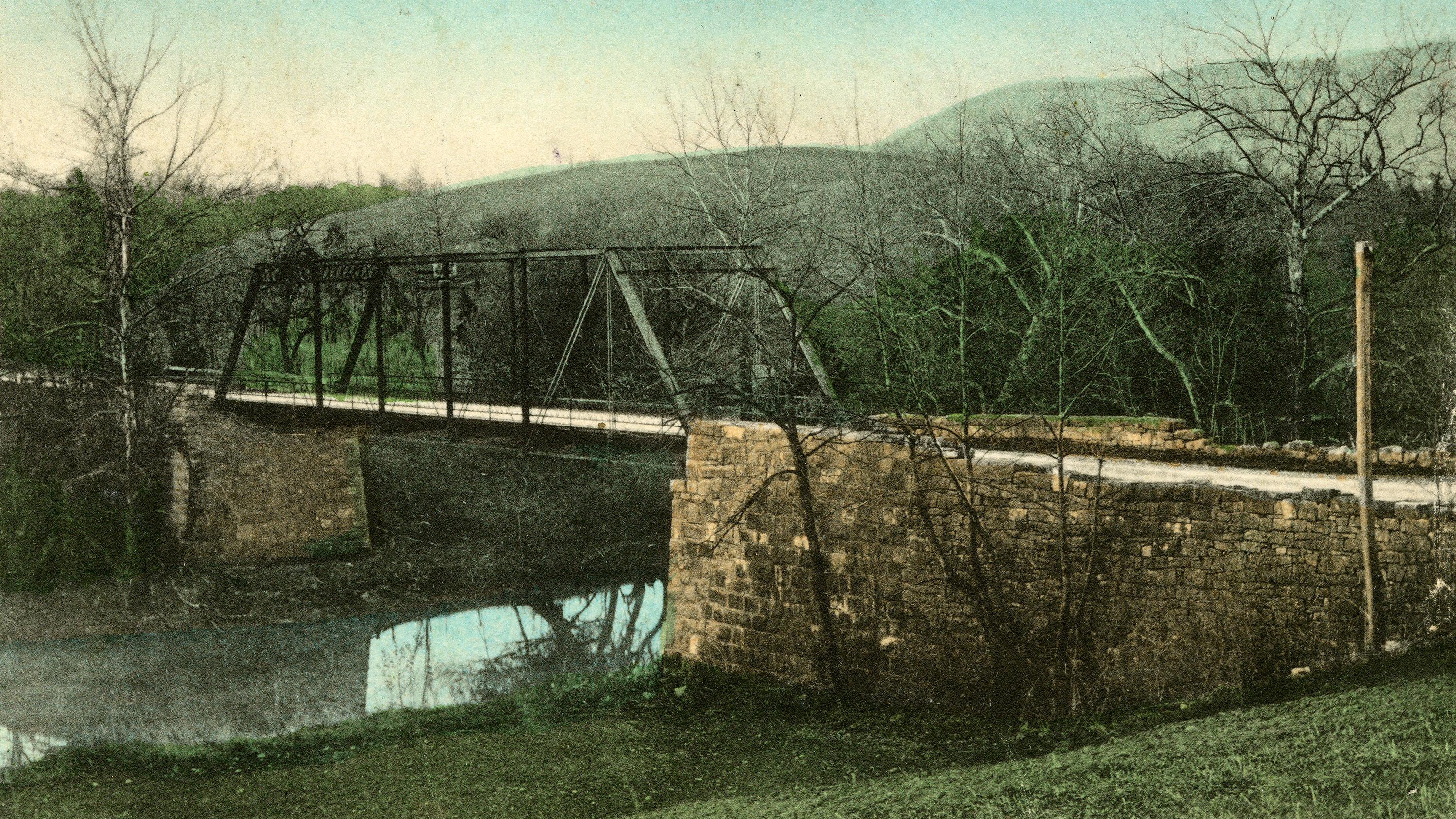 Stone bridge abutment ruins on the right bank of wide creek.