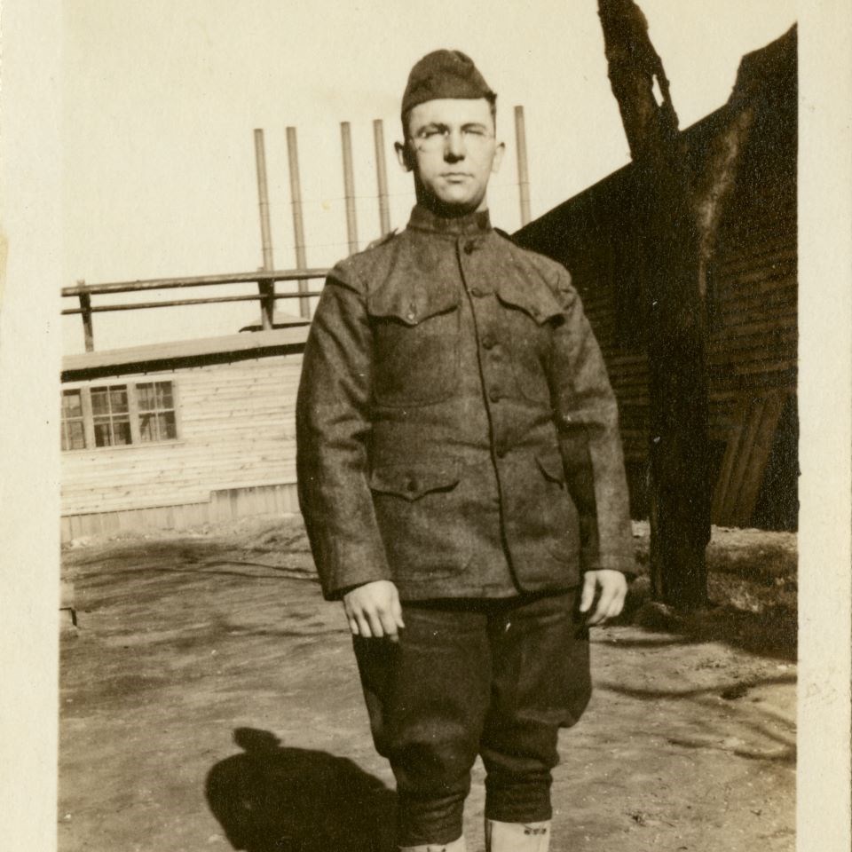 WWI soldier in front of buildings that may have served as hospital buildings at Fort McHenry during its time as a WWI hospital.