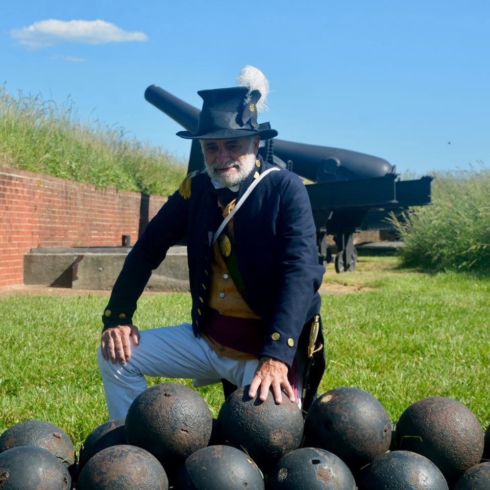 A solider in 1919 sits here, with his feet resting on cannon balls used as Fort McHenry’s ammunition.