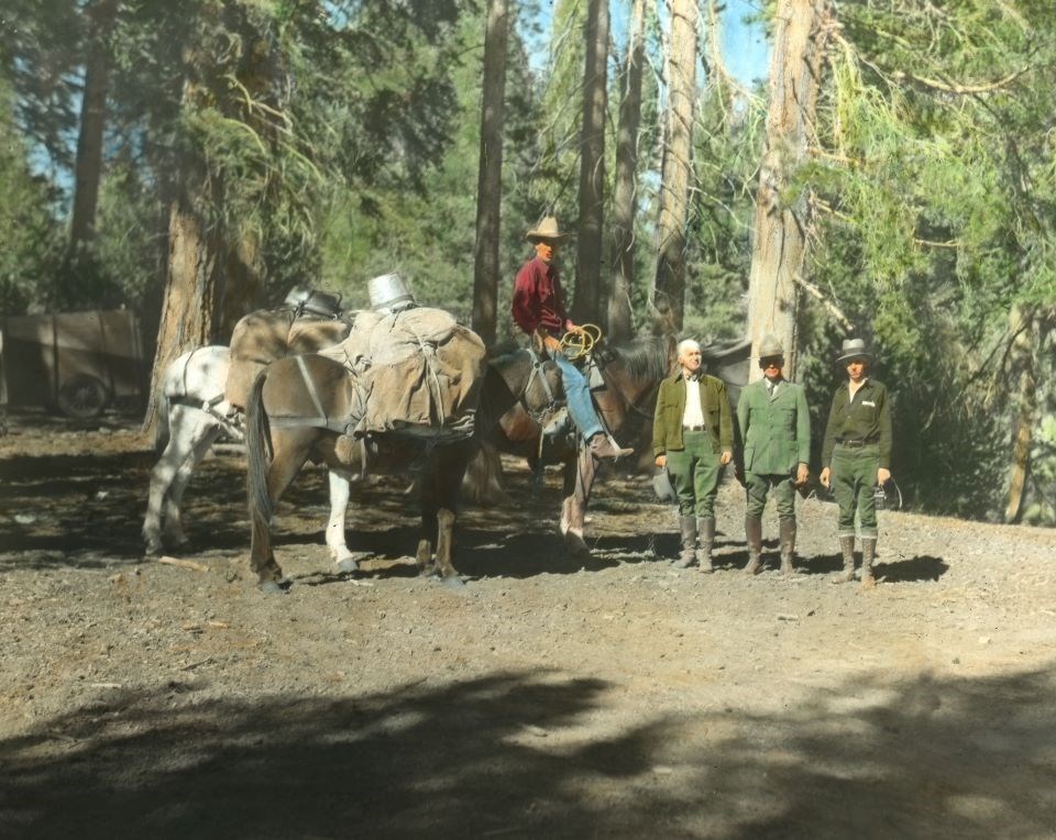 Black and white photo of park rangers with horses.
