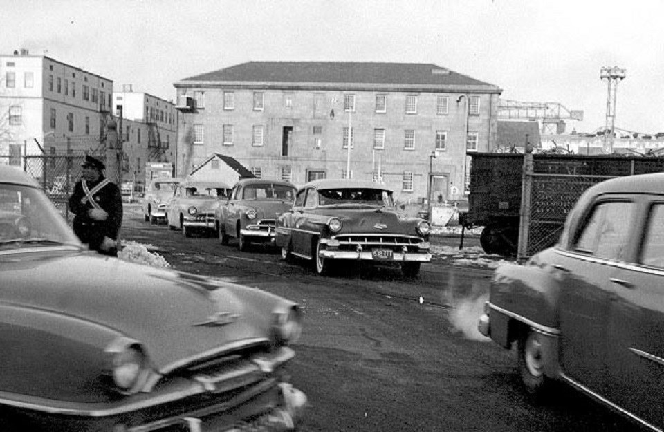 USS Constitution Museum building in the distance with mid-century cars in front of it.