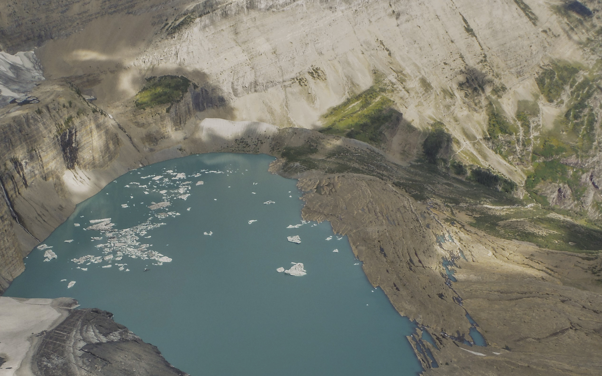 a bright blue lake with ice floating in it