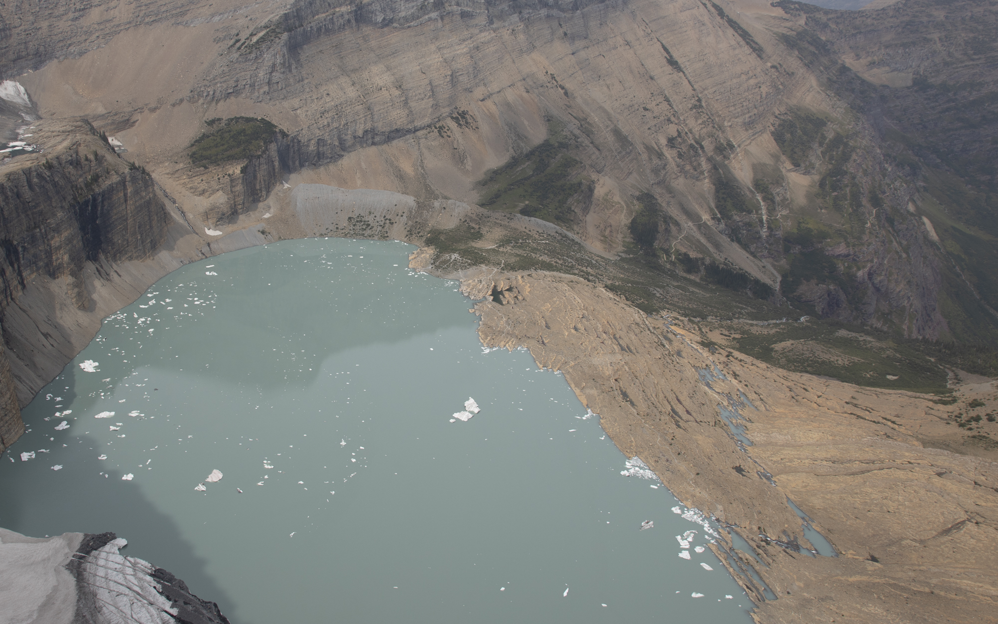 a bright blue lake with ice floating in it
