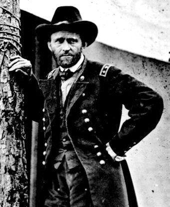 Photo of Ulysses S. Grant leaning against a tree trunk in front of a white canvas tent.  