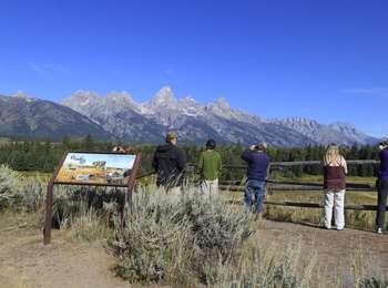 Blacktail Ponds Overlook with visitors looking out over the channel of the Snake River toward the Teton Range.
