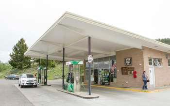 Square brick building with glass front and canopy over the gas pumps.