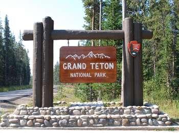 North Grand Teton Entrance sign, brown wooden on cobble rock base
