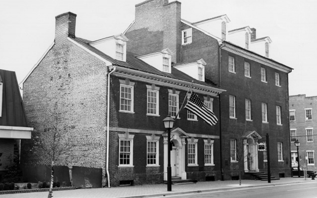 Black and white photo of brick building with flag 