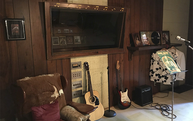 Interior, control room, studio window, with guitars, music stand and records
