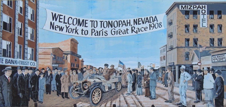 Painting of old race car with people, buildings, and banner.