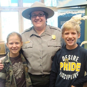 A ranger stands flanked by two junior rangers