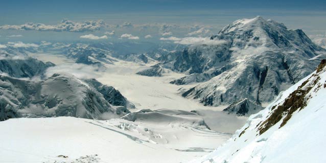 impressive vista of steep snowy mountains and large, winding glaciers