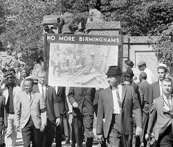 B&W photo of marchers holding 'No More Birminghams' sign