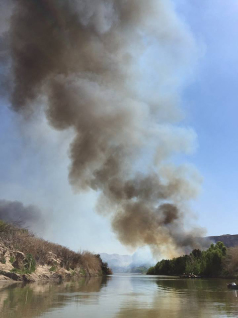 Firefighters canoeing on the Rio Grande during a prescribed burn along the Rio Grande 