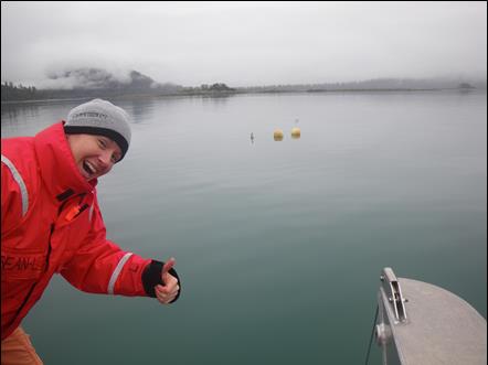 researcher in orange coat gives thumbs up