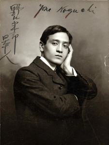 A man in a suit poses with one hand on the side of his face