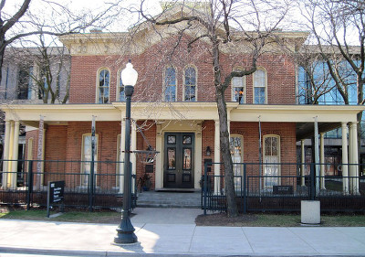 Outside of the Hull House, a two-story brick house with columns