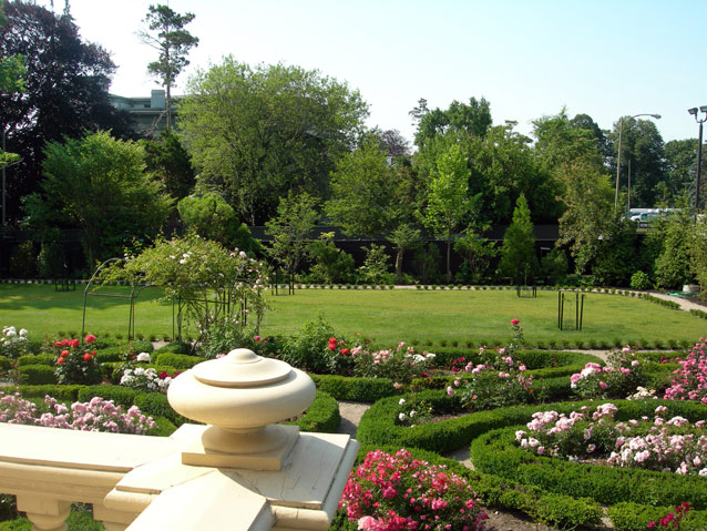 View over the edge of a railing to an ornamental garden with beds lined in boxwood