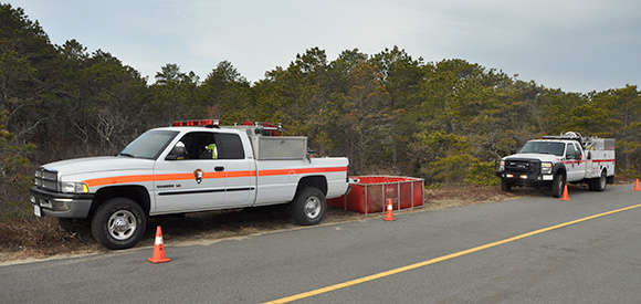 Two wildland fire engines parked off the road.