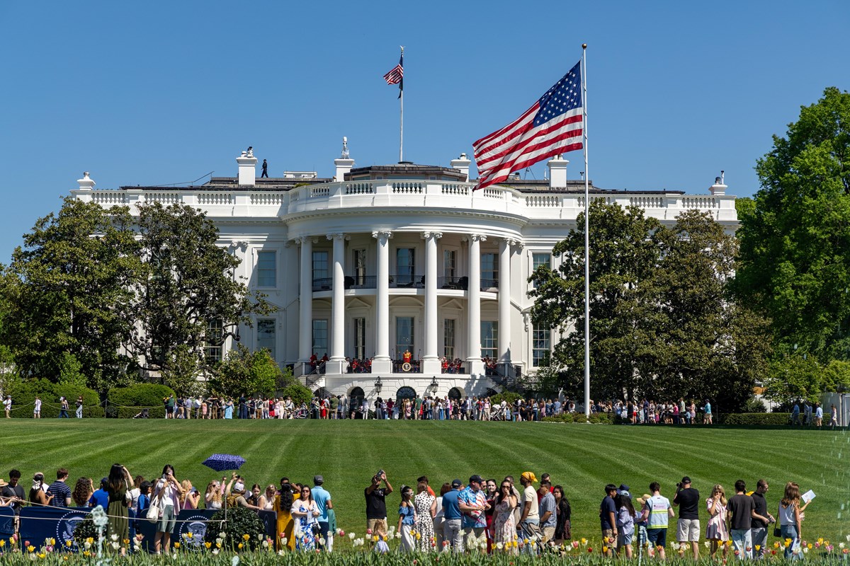 Crowds of people populate the White House South Lawn on a sunny day with the White House in view
