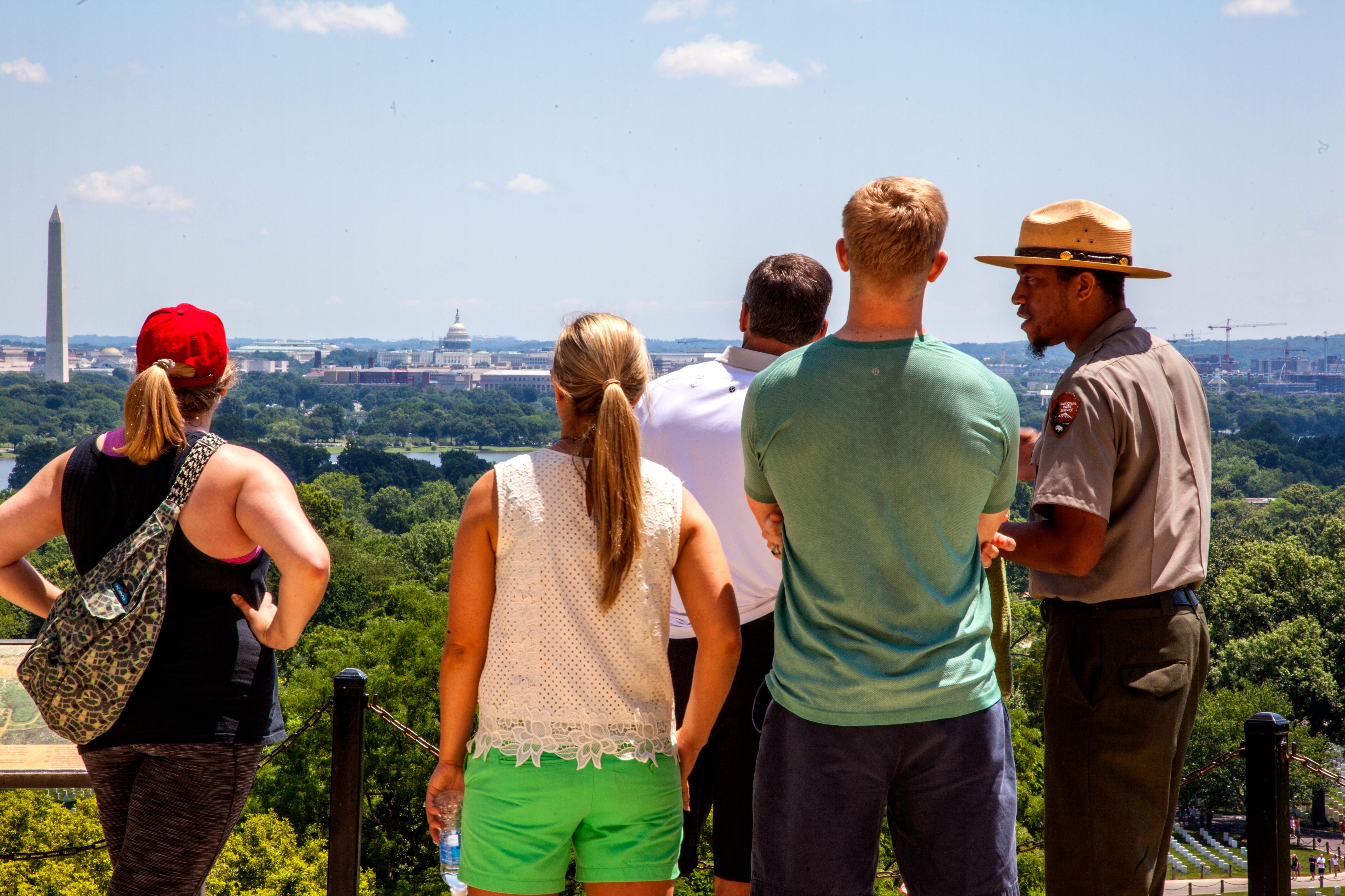 A park ranger talks to people overlooking Washington, DC