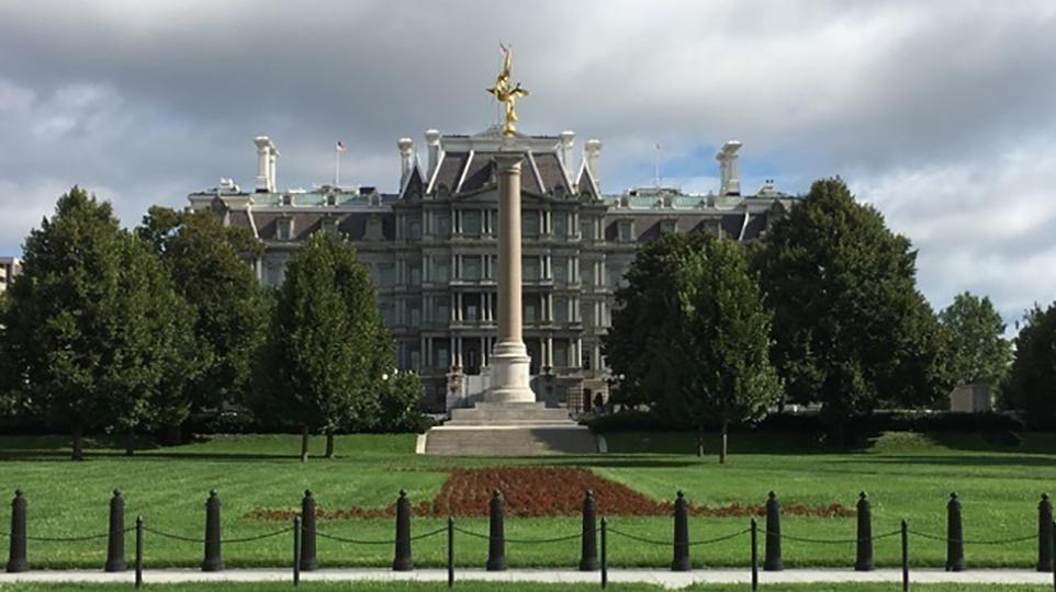 A tall stone column with a golden, winged figure on top.