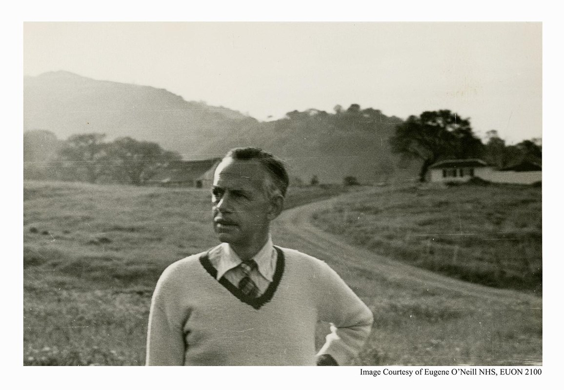 Eugene O'Neill, and older man, poses outside against a hilly background.