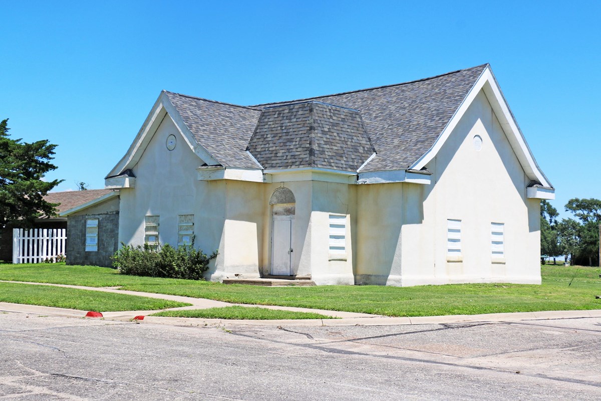 A limestone stucco building on a street corner