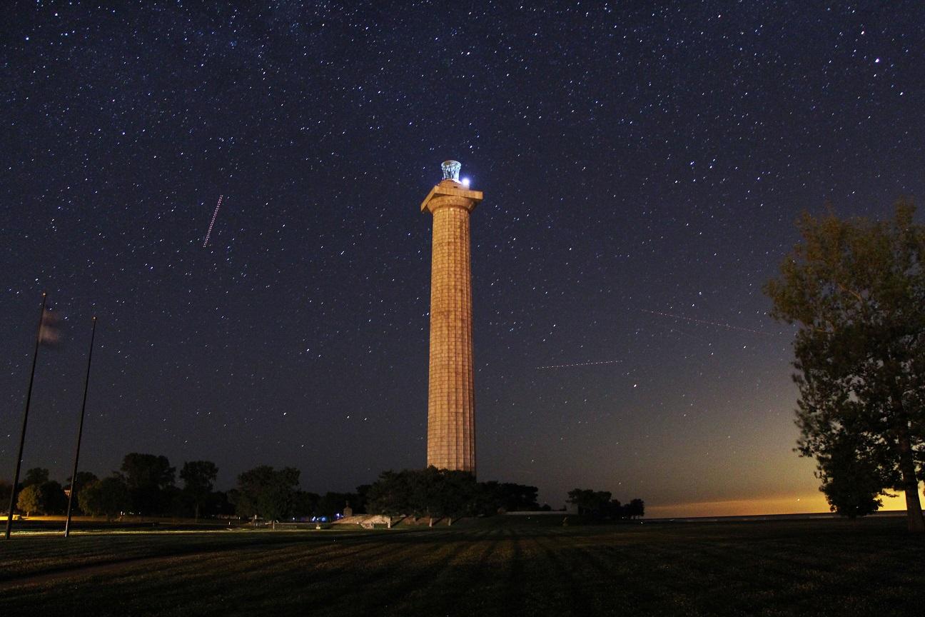 Night sky with Memorial Column in the middle with sun just starting to come up in lower right corner