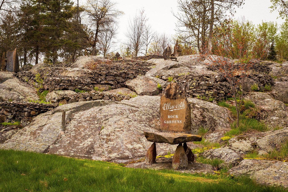 Photograph of landscape with large boulders and rock sculptures.