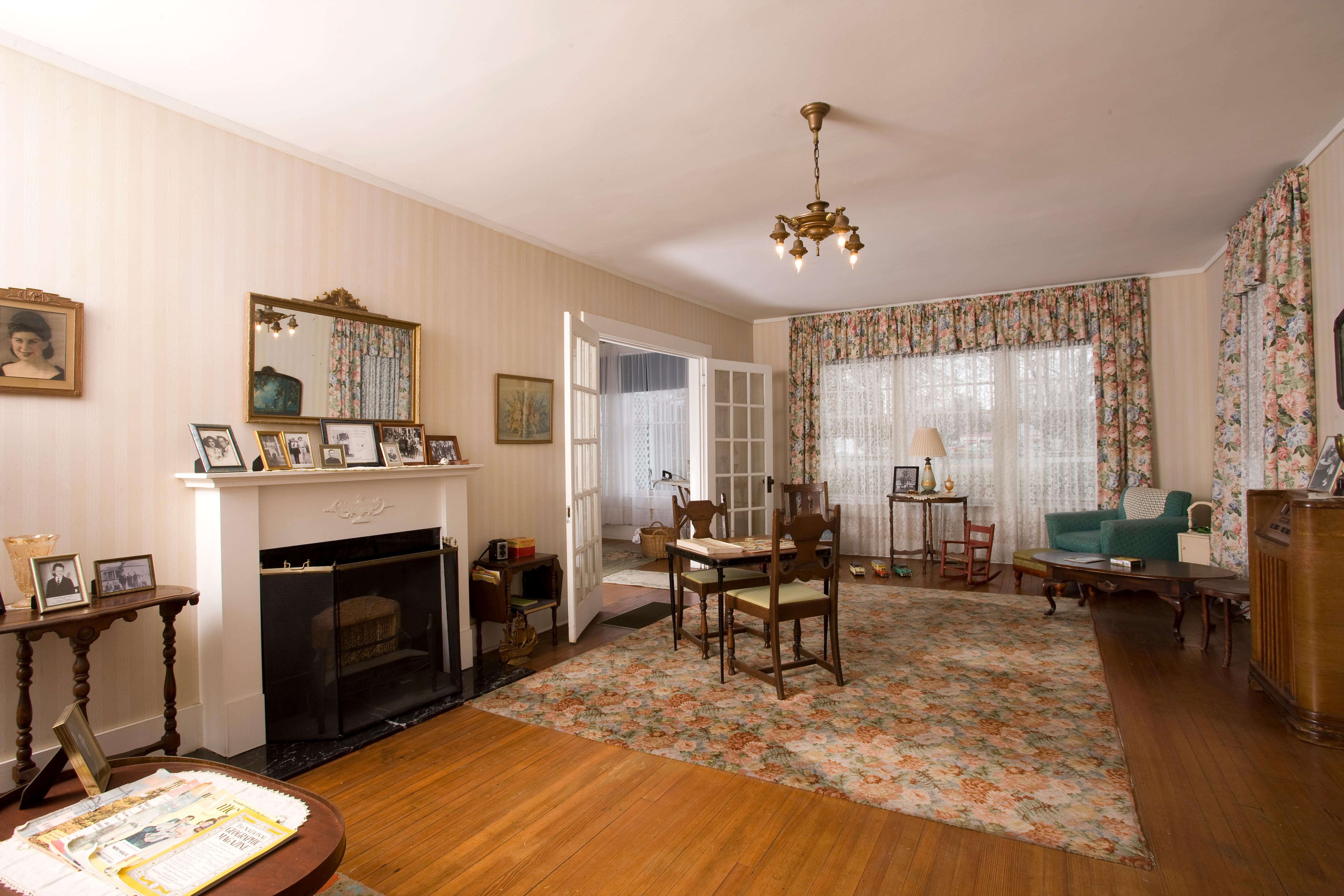 A view of the living room with a fireplace, rug, recliner and other furniture