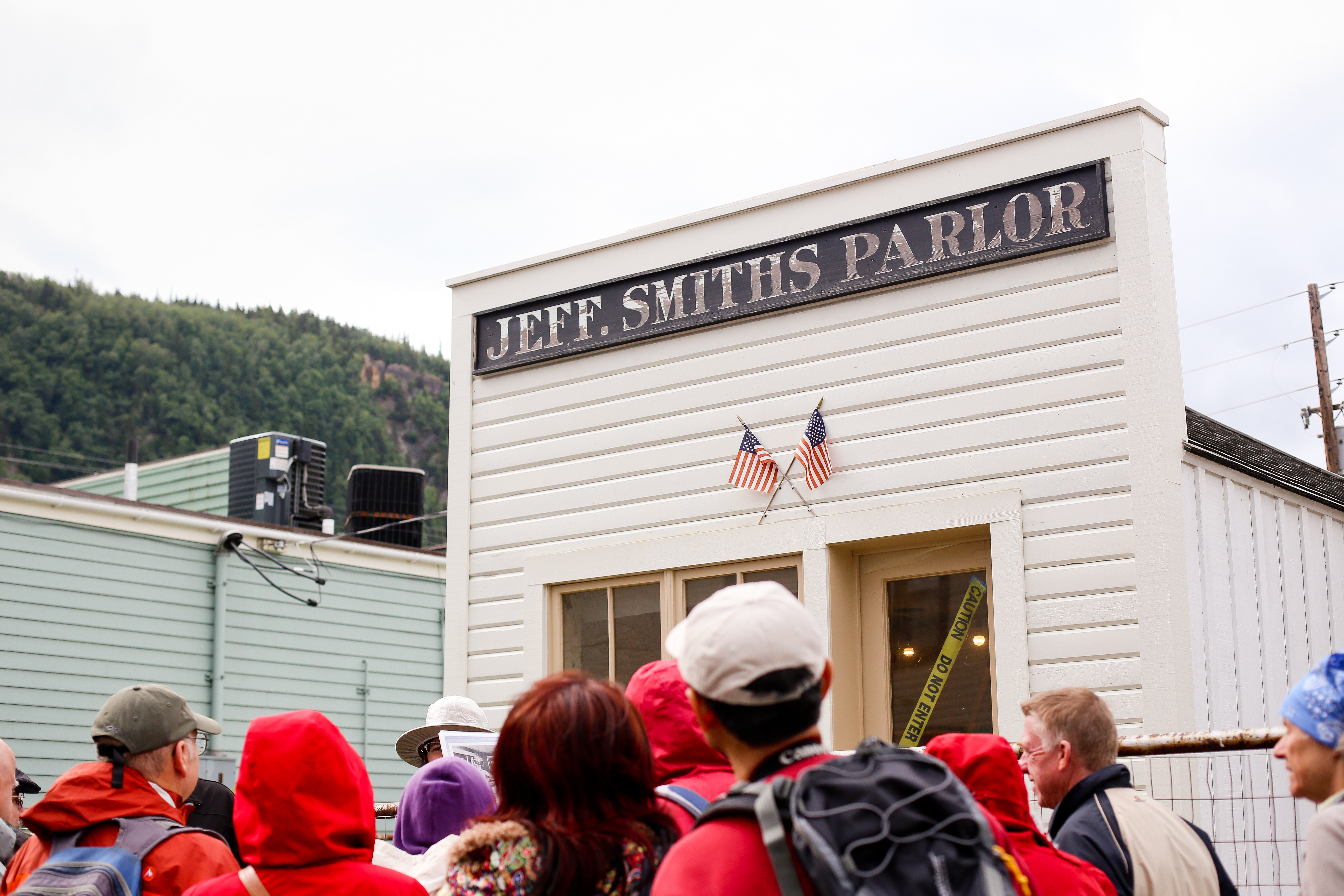 People standing around a ranger in front of a building.