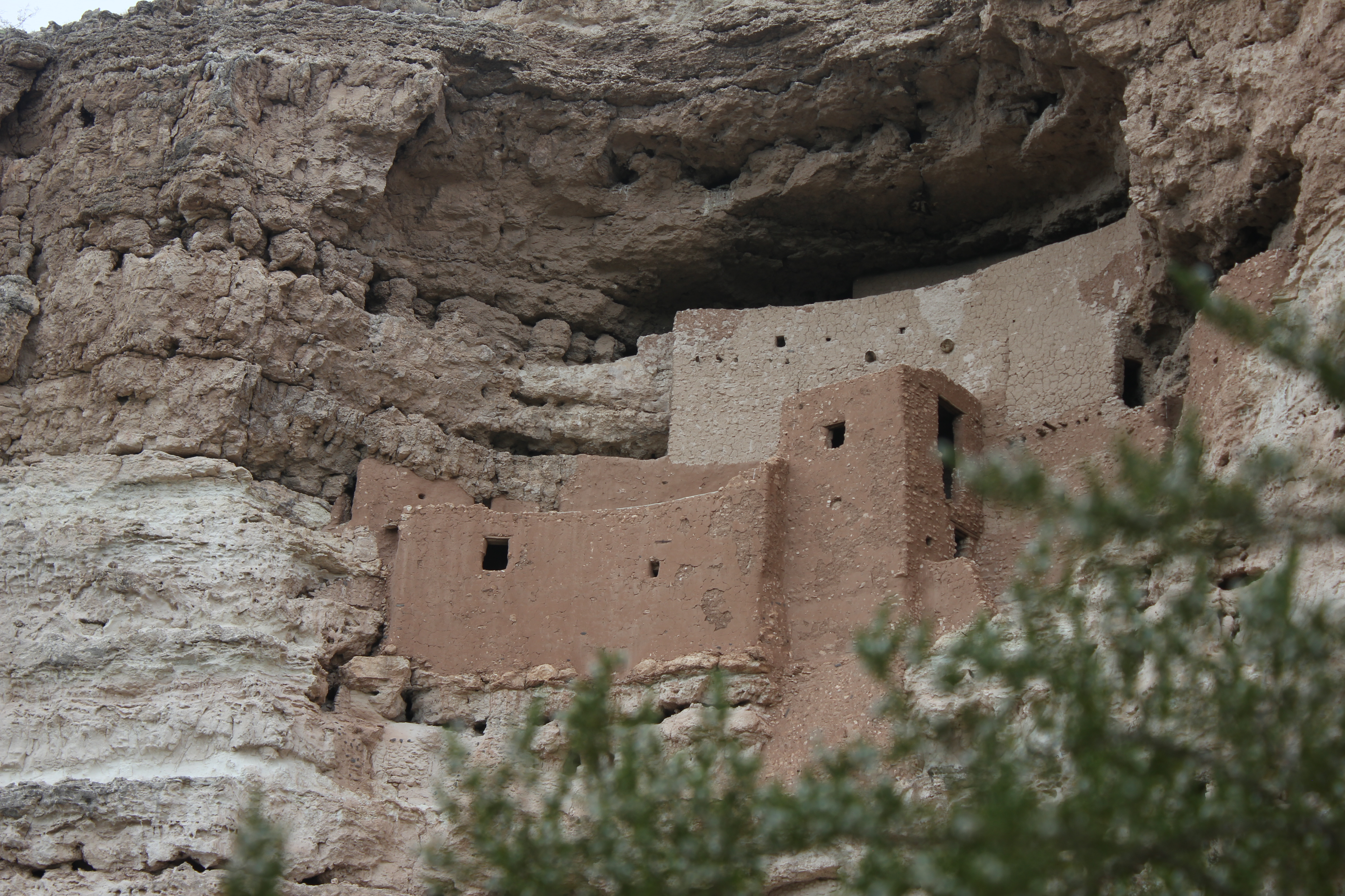 A 5-story masonry dwelling sits in a cliff alcove.