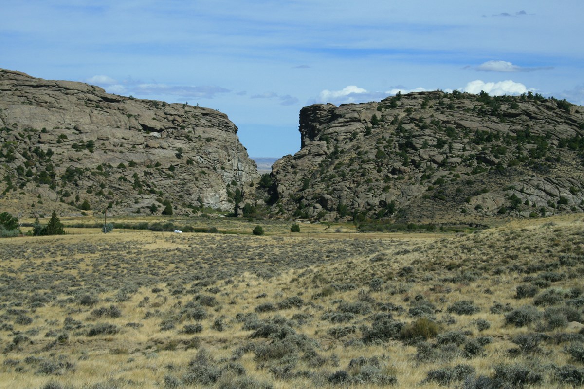 A rock buttress with a notch in it surrounded by sagebrush flats.