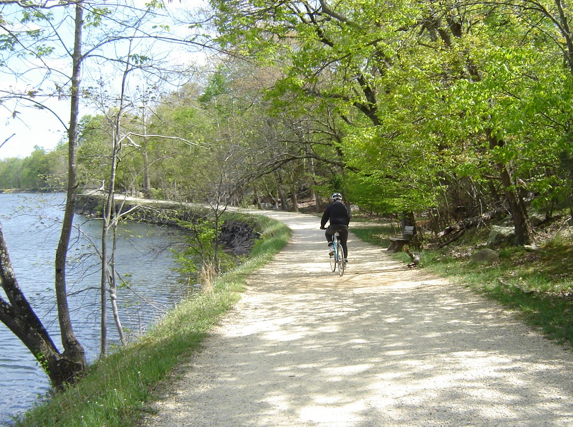 A single bike rider on the towpath next to the widewater section of the canal.