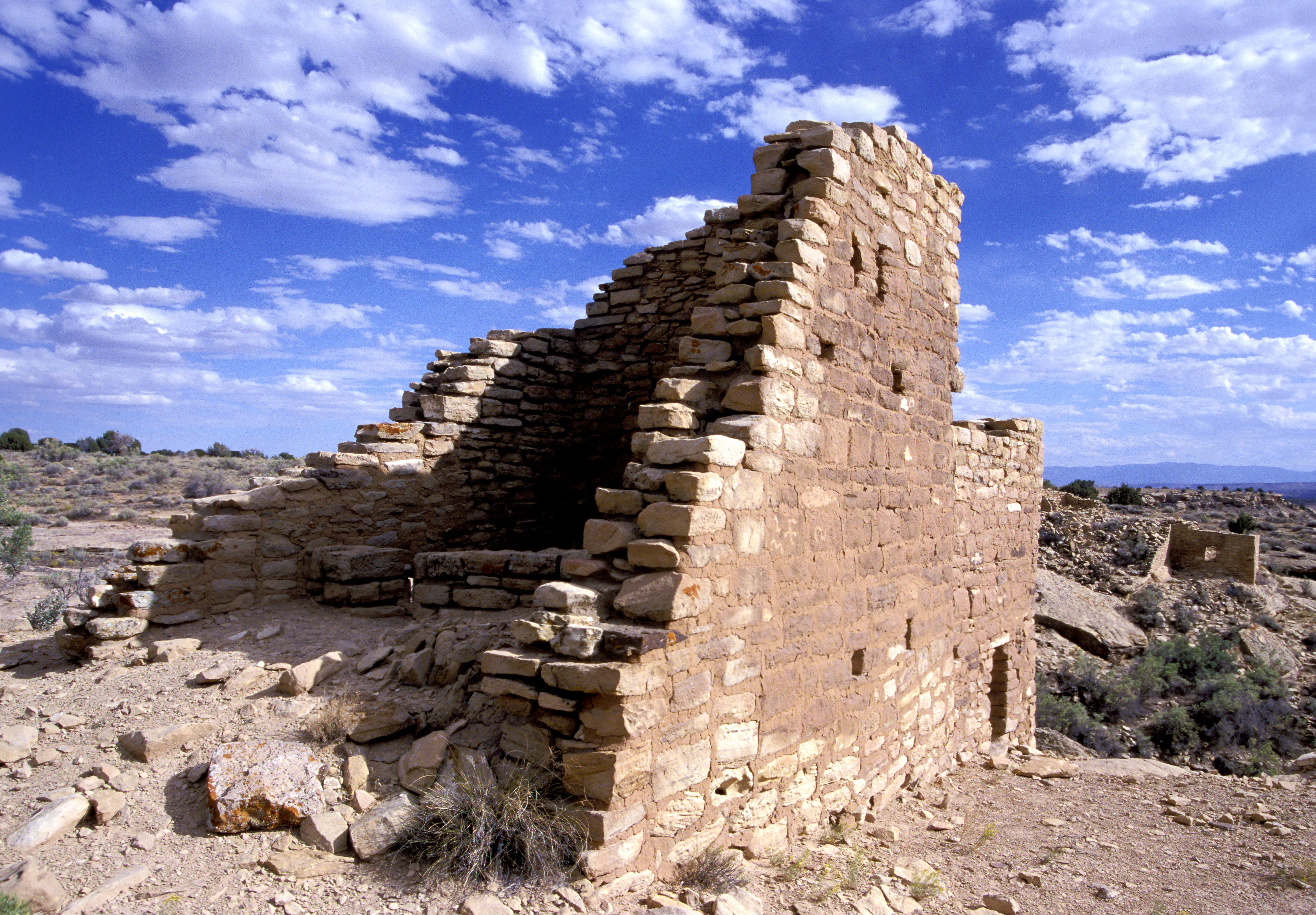 a stone structure with blue sky and clouds overhead