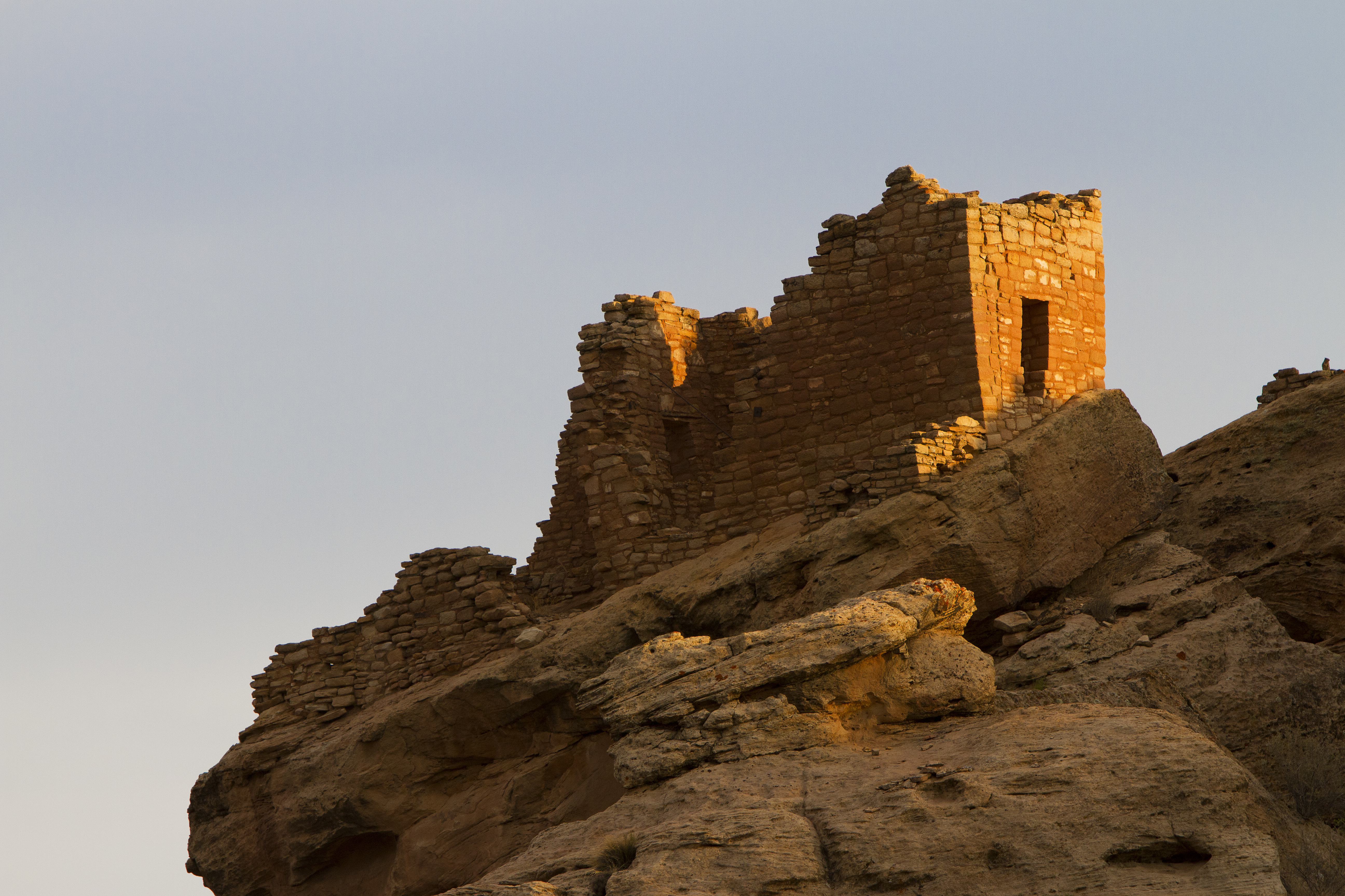 a stone structure resting on a cliff edge