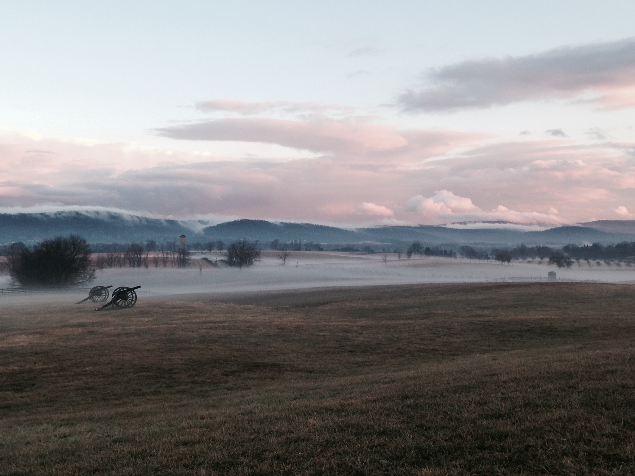 fog filling in the low areas of the field at sunset