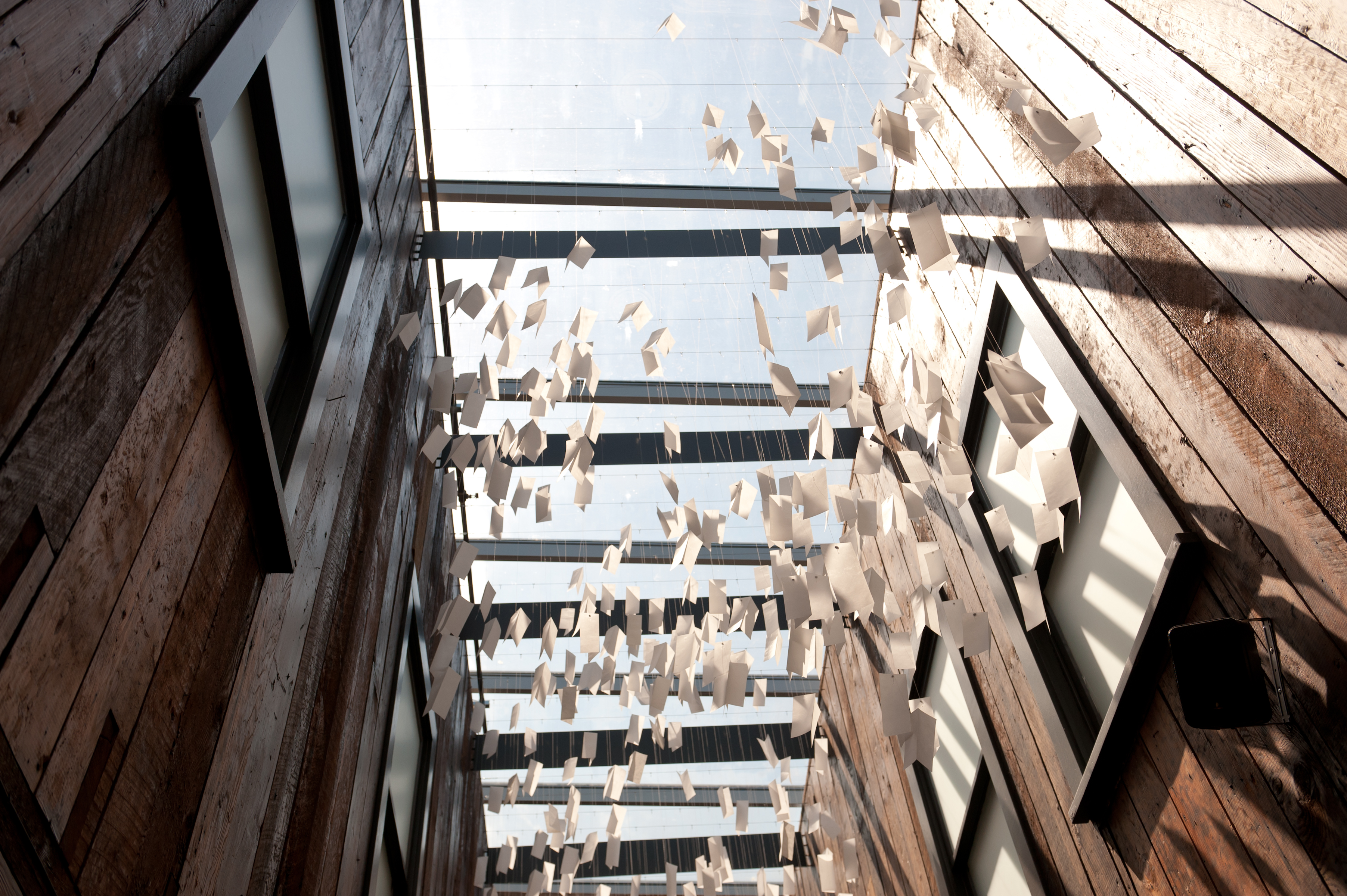 a mobile of letters written on white paper hangs in the museum lobby