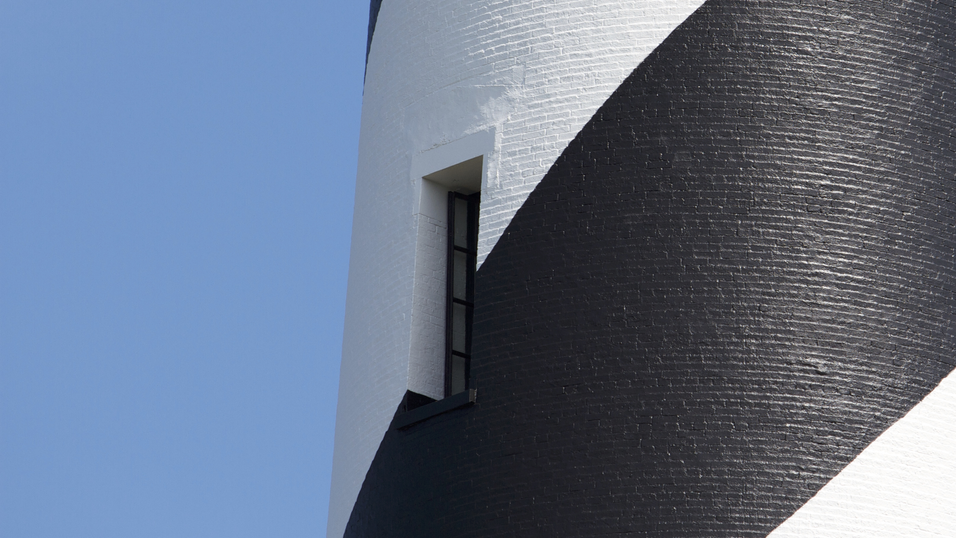 Black and white painting of the brick Cape Hatteras Lighthouse.