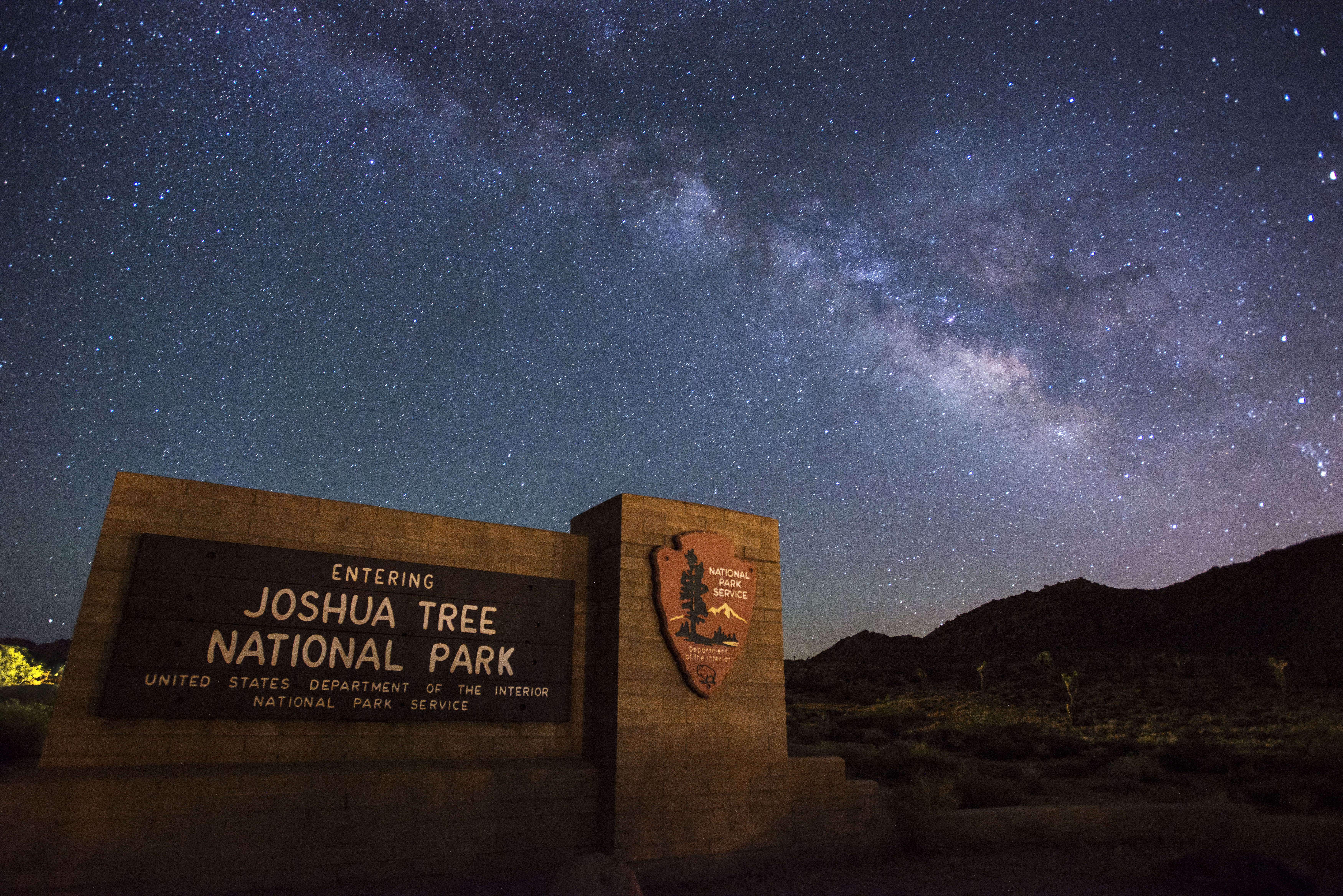 night scene showing stars of the Milky Way over a sign saying 