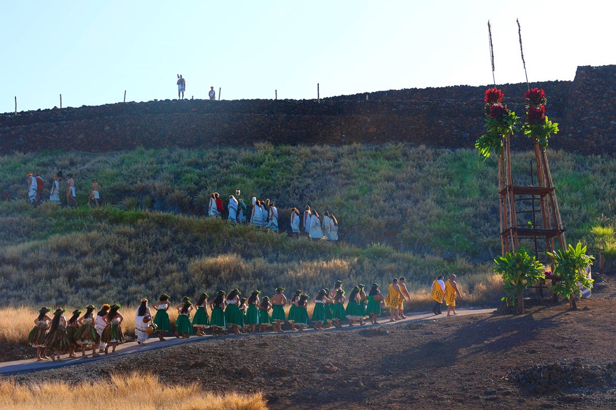 Ceremony procession along a heiau at sunrise.