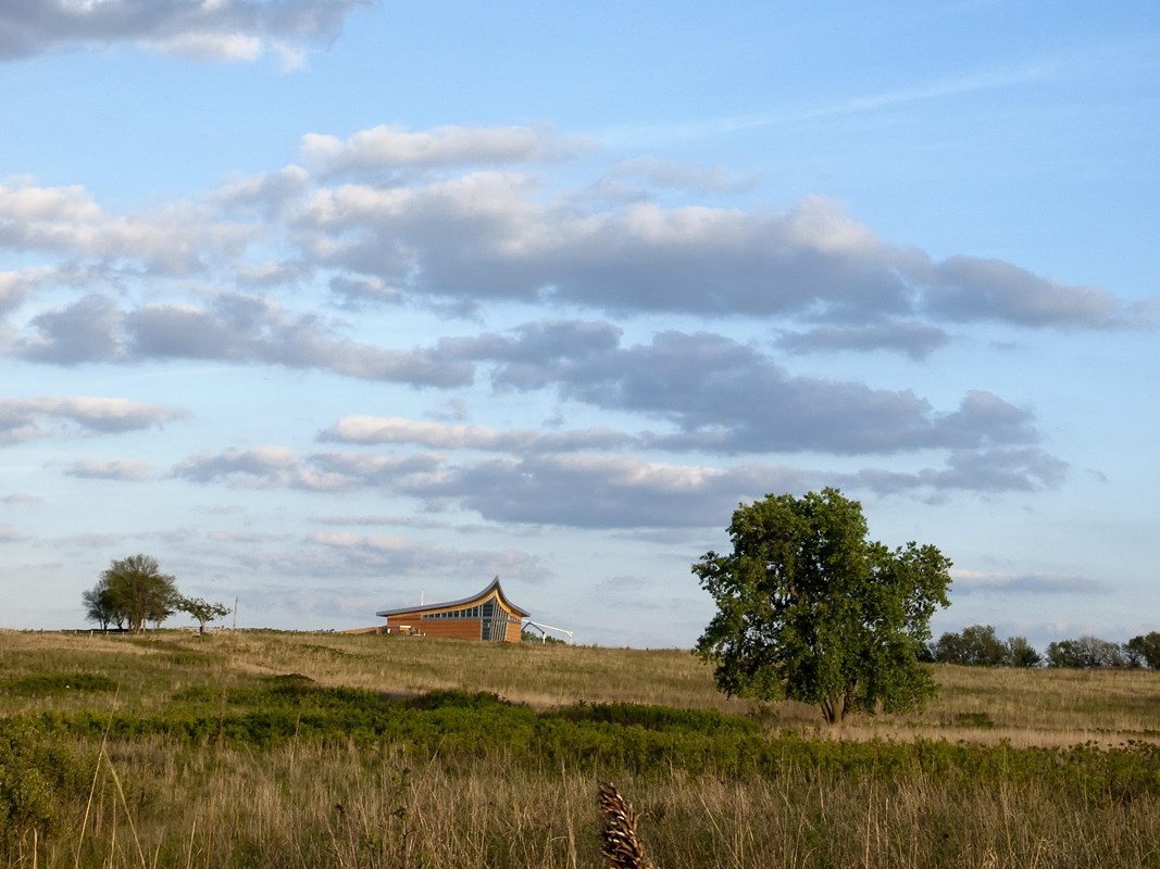 The tallgrass prairie spans to the Heritage Center on the horizon.