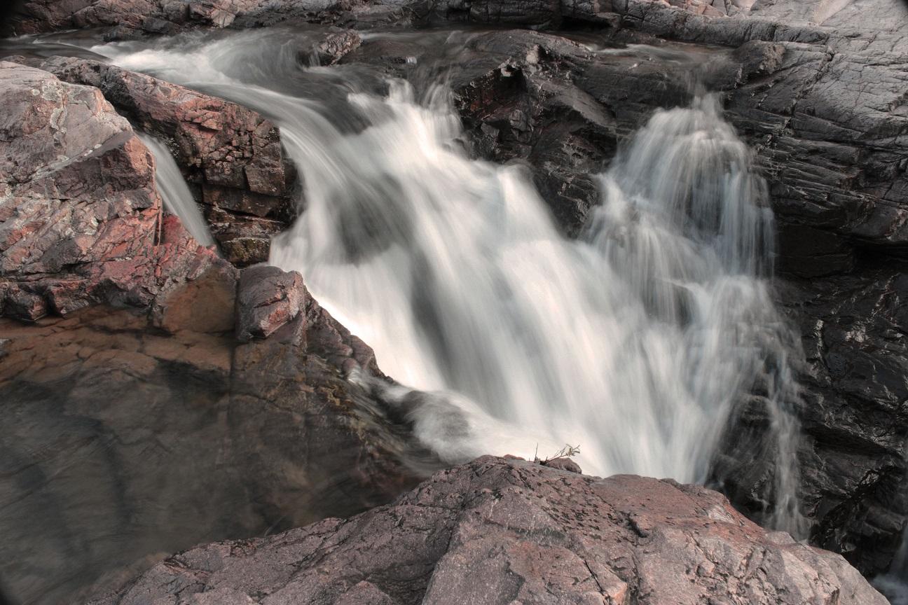 brown rocks with water flowing over like a waterfall