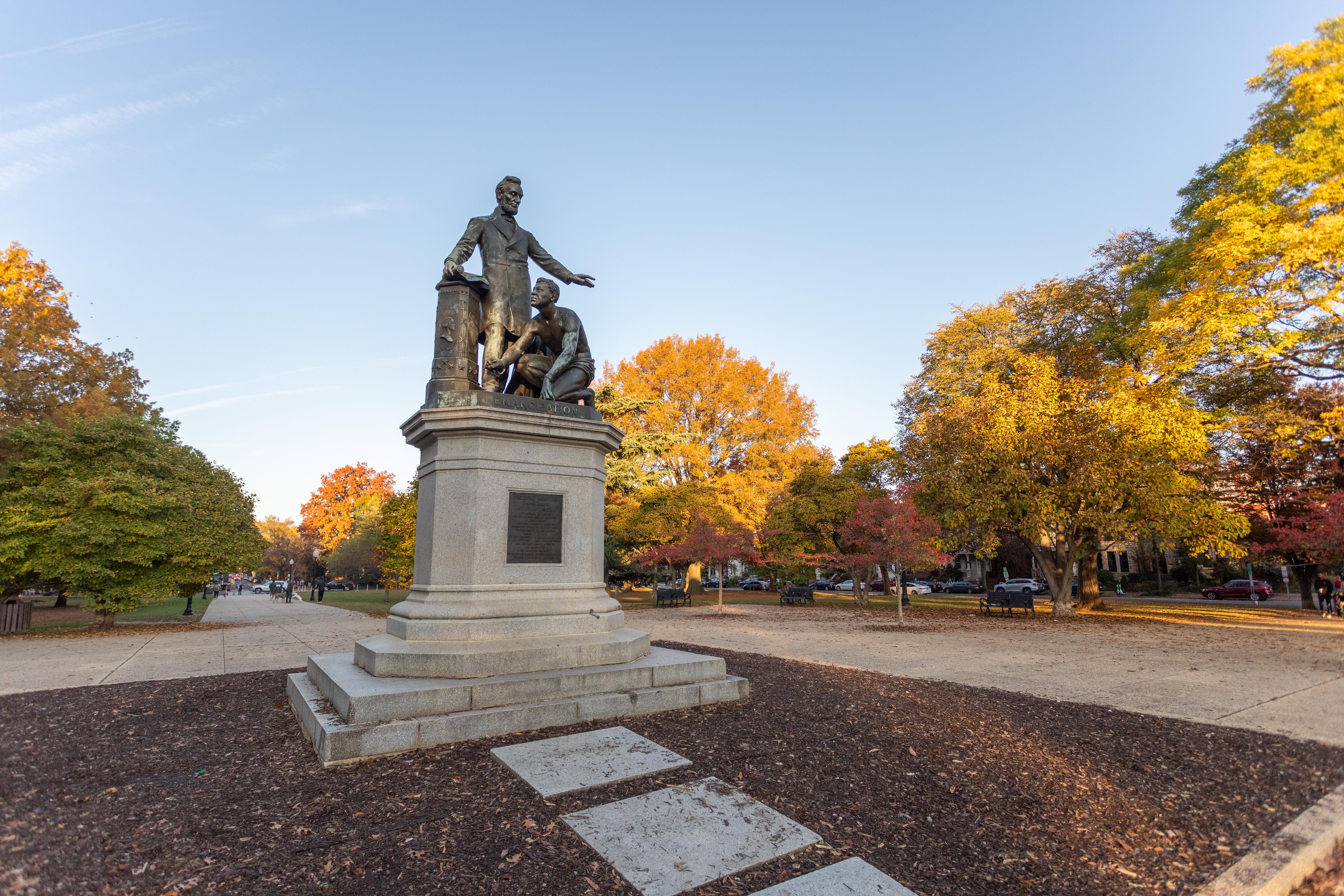 Bronze statue of Abraham Lincoln standing over an enslaved man rising from kneeling.