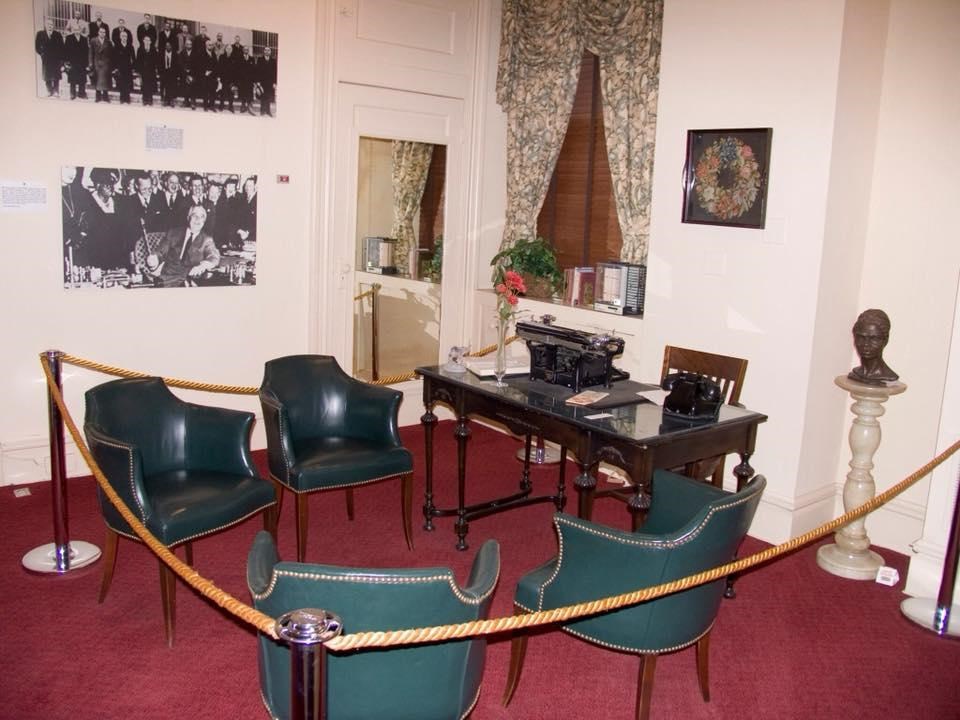 A desk and chairs roped off with other furnishings and objects mounted on the walls