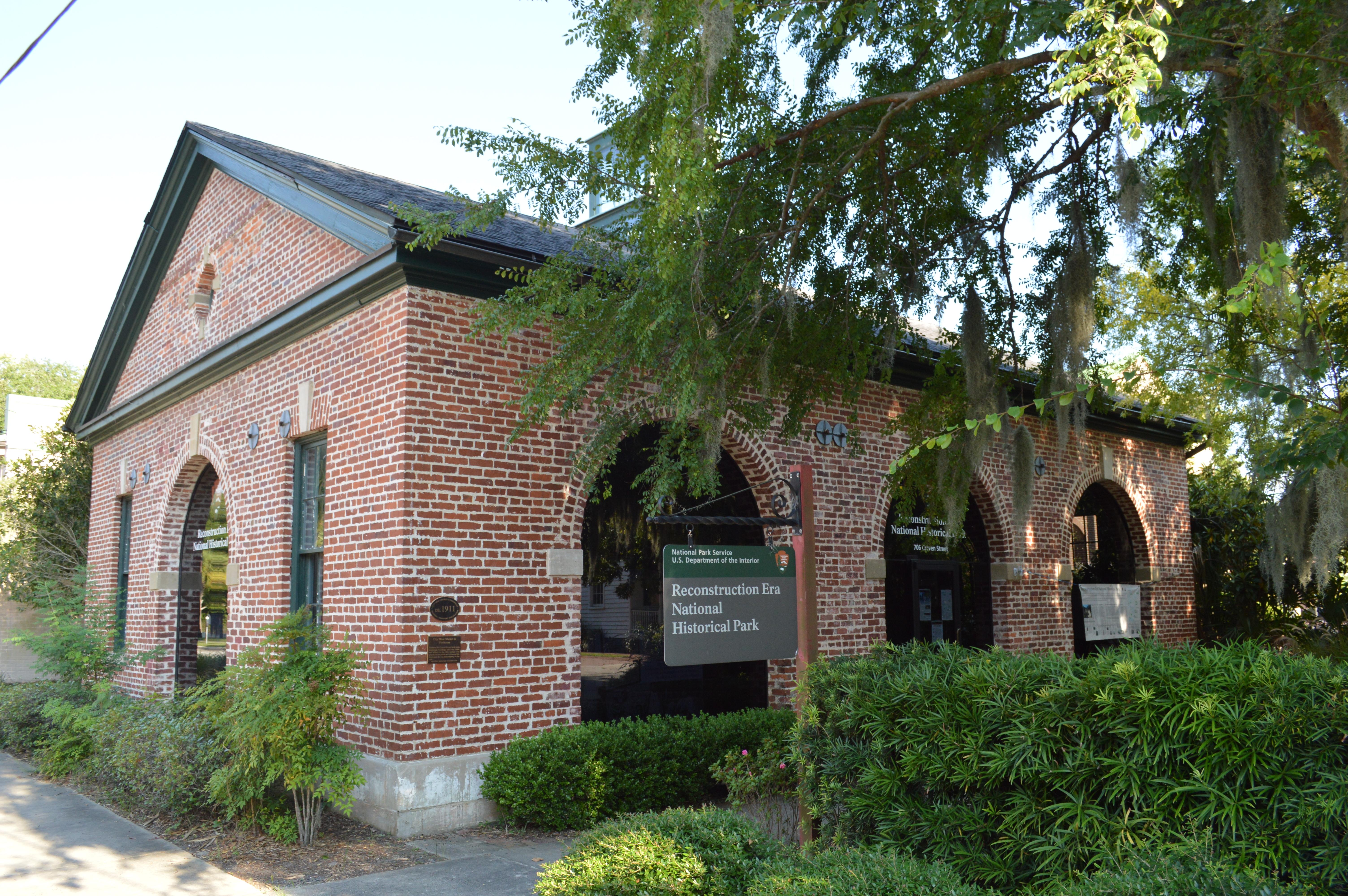 A one story brick building with large arched windows