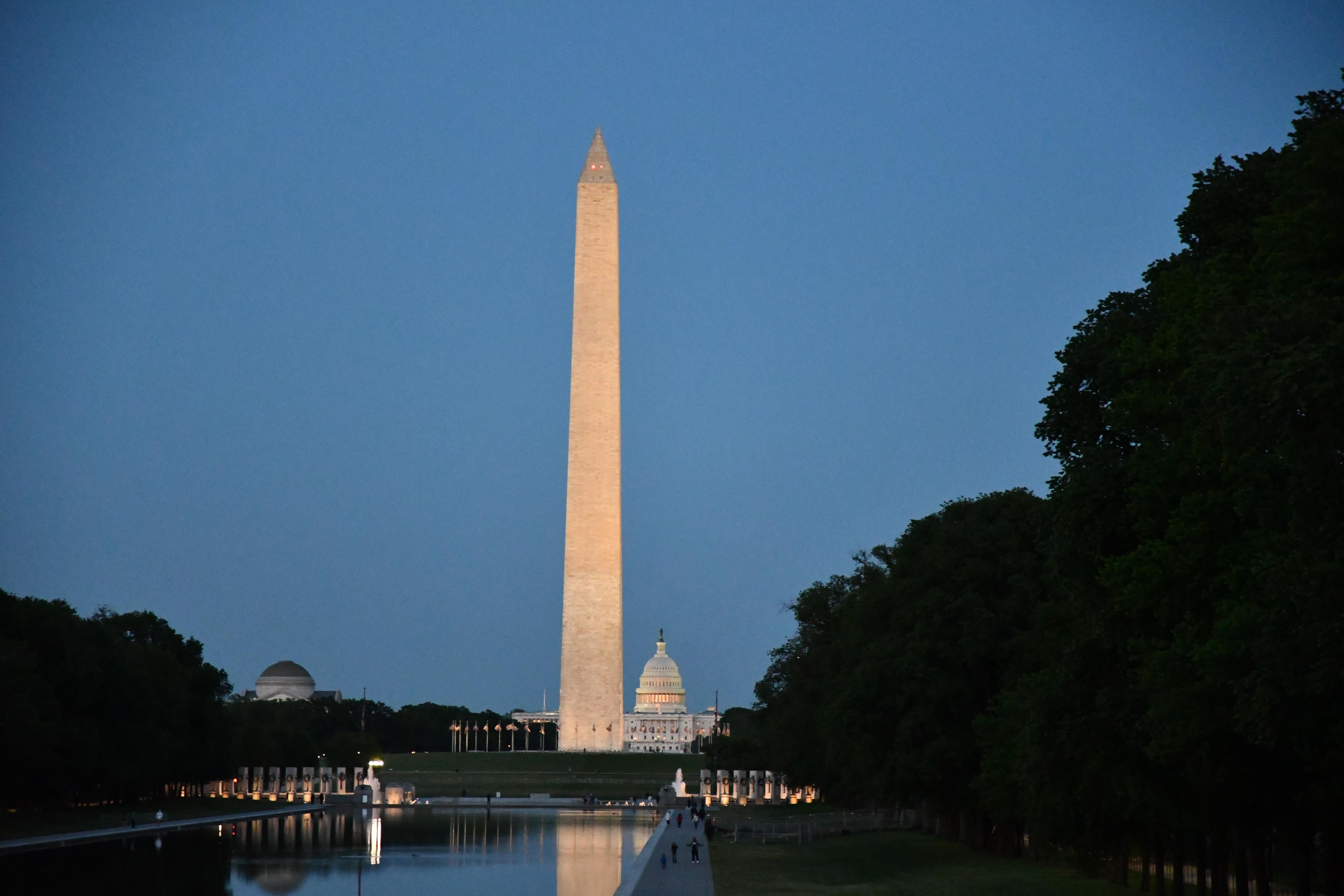 Reflection on Washington Monument along pool with US Capitol in background